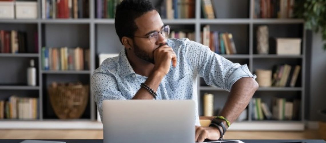 african-businessman-sitting-at-workplace-thinking-over-problem-picture-id1253877157 (1)